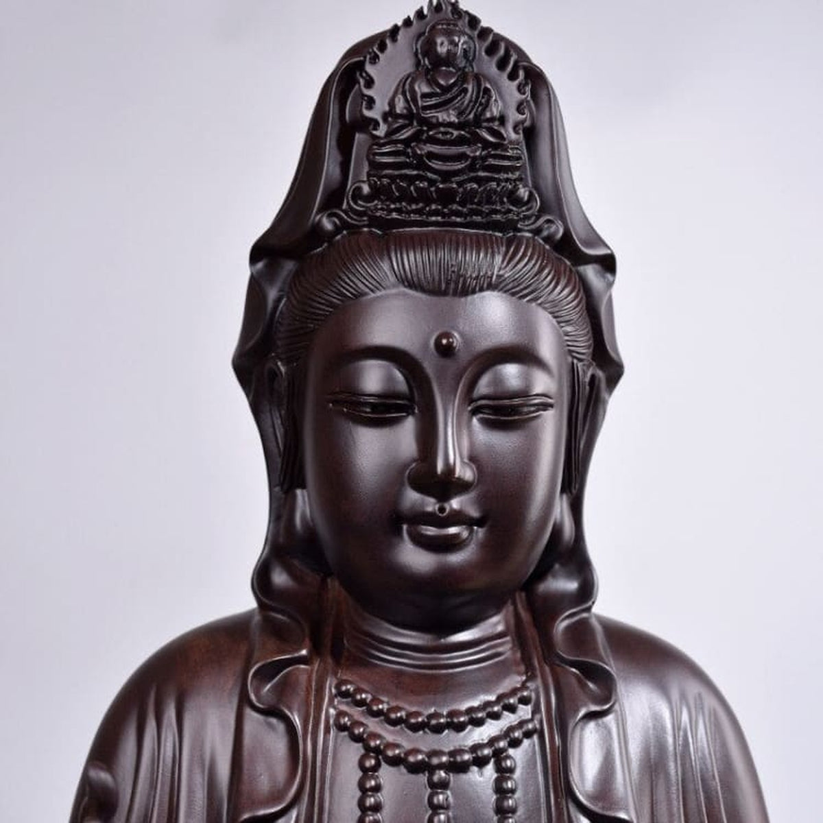 Détail du visage, de la couronne et du geste de la main droite de Guanyin