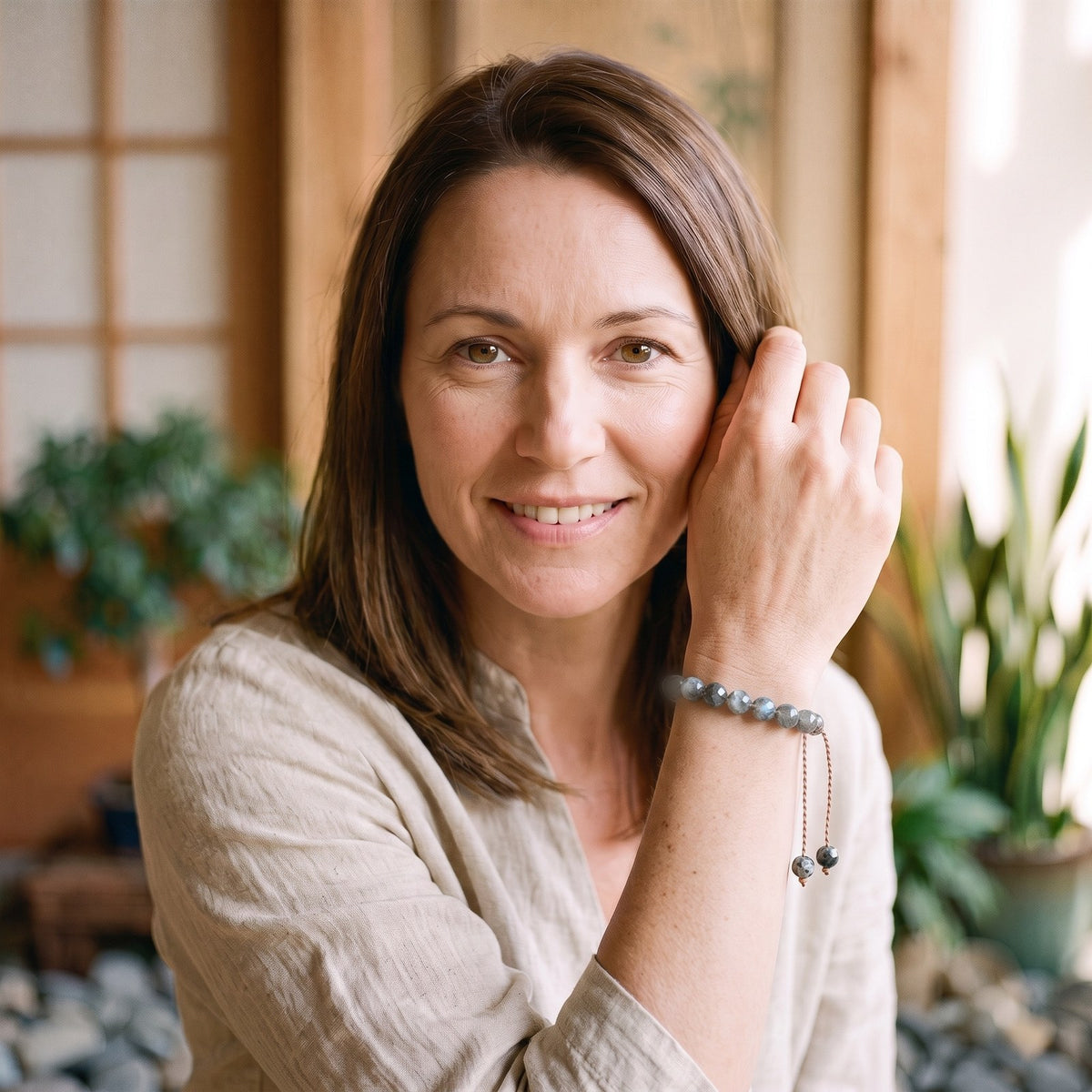 Femme souriante portant le bracelet en labradorite facettée au poignet