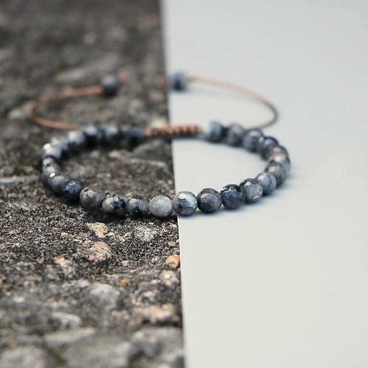 Bracelet en labradorite facettée posé sur une pierre brute