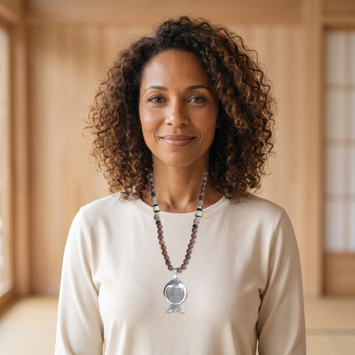 Femme du casting souriante portant le collier vintage au grand poisson