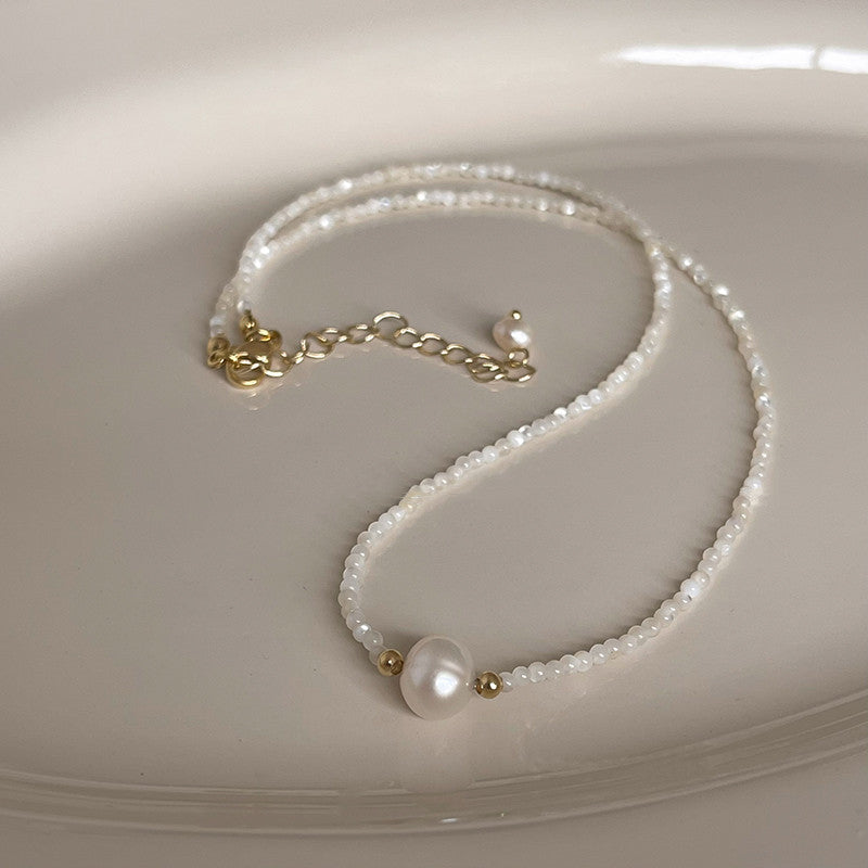 Collier en pierre naturelle en perles d'eau douce posé sur une assiette blanche