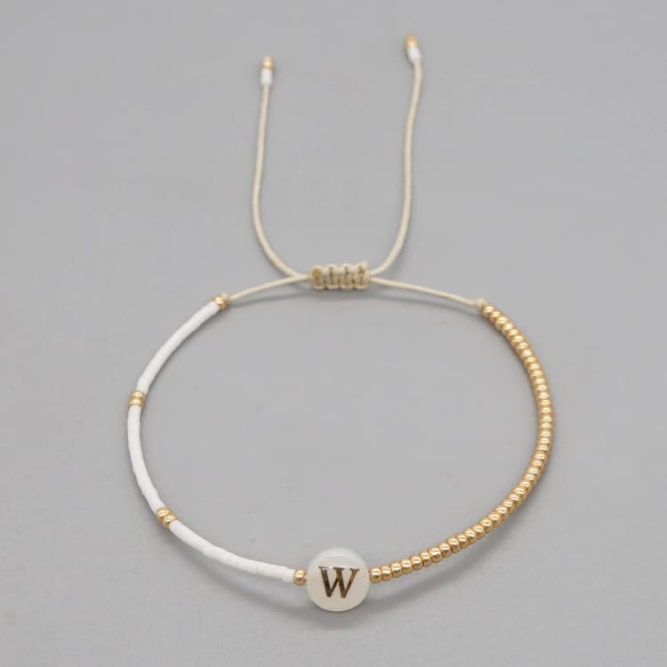 Bracelet en perles de coquillage avec pendentif initiale