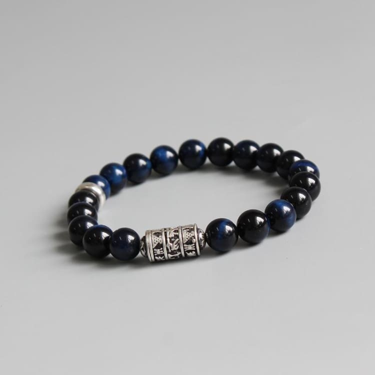 Bracelet de perles bleu nuit chatoyantes avec tube gravé en argent tibétain au centre